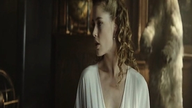 Supermodel Doutzen Kroes reclines overhead a bed in a corset