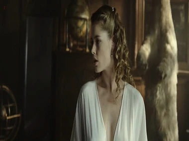 Supermodel Doutzen Kroes reclines overhead a bed in a corset